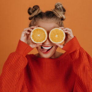mujer feliz con naranjas en la cara